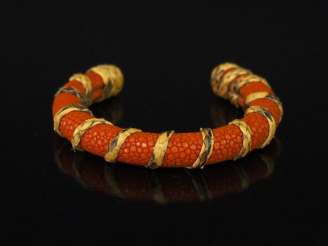 Vente aux enchères Bracelet jonc en galuchat orange, agrémenté d'un motif d'enroulement. 