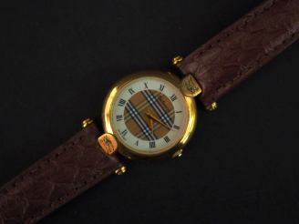 Vente aux enchères BURBERRYS,  Montre bracelet, boitier en métal doré.  Cadran rond à chi