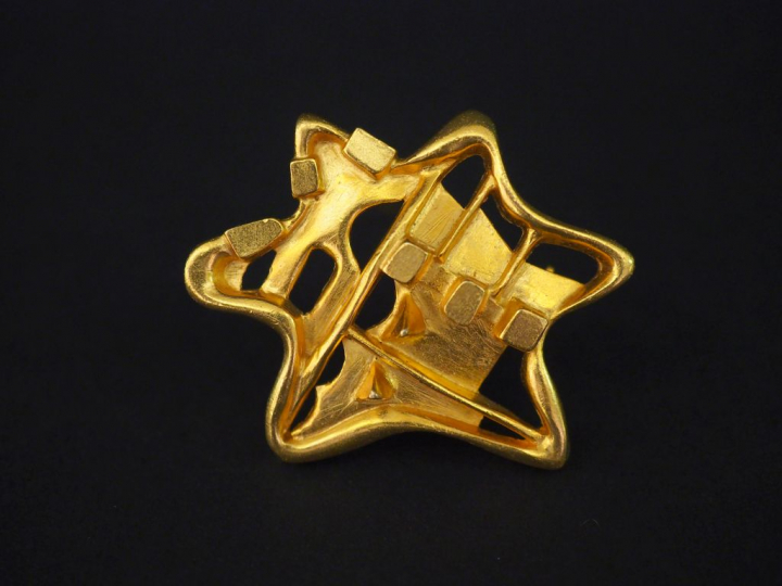 Christian LACROIX Broche en métal doré en forme d'étoile, à décor abst