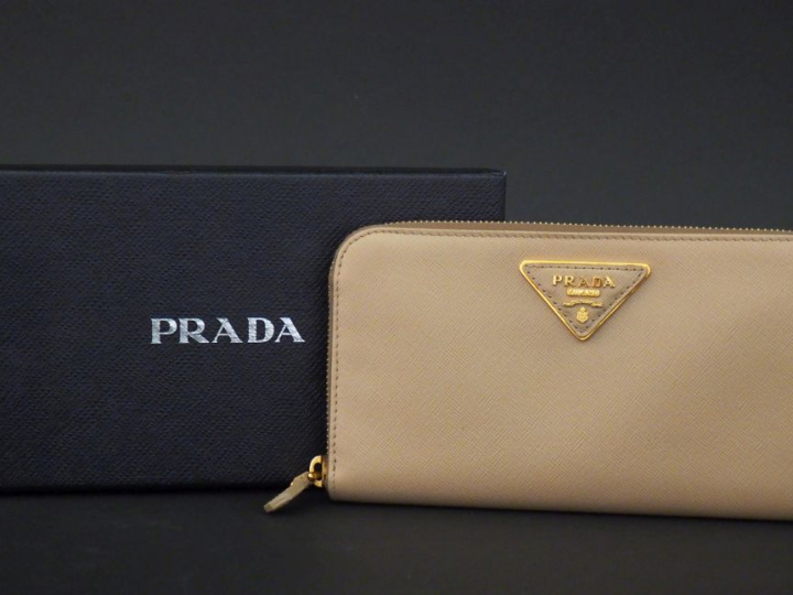 PRADA,  Portefeuille en cuir crème.  Fermeture à zip.  Poches intérieu