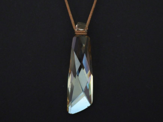 Vente aux enchères SWAROVSKI Pendentif en cristal fumé.  Cordon marron. Signé du monogram