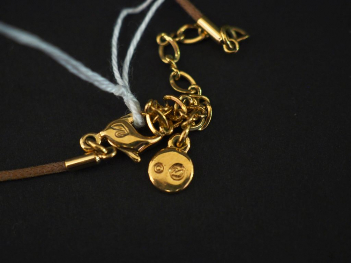 SWAROVSKI Pendentif en cristal fumé.  Cordon marron. Signé du monogram