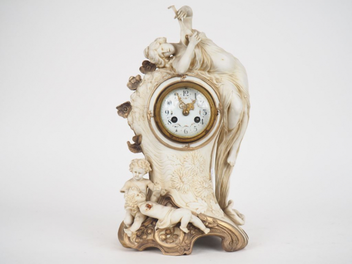 ROYAL DUX.  Pendule en biscuit polychrome à décor de musicienne et d'a