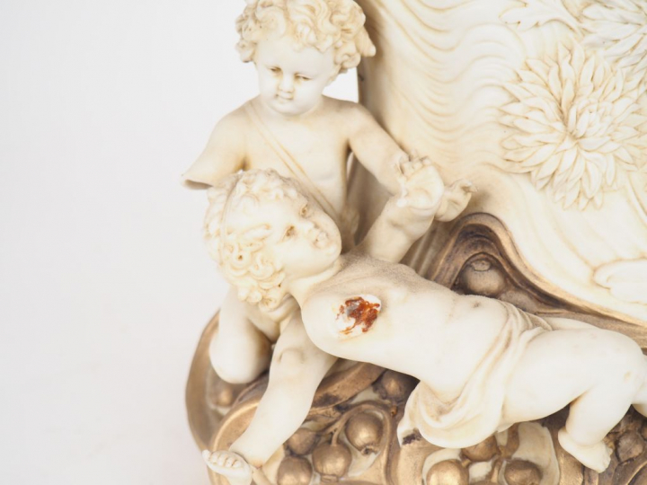 ROYAL DUX.  Pendule en biscuit polychrome à décor de musicienne et d'a