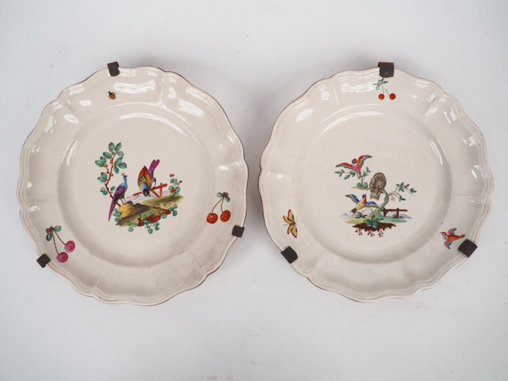 Paire d'assiettes en faience à décor polychrome d'oiseaux branchés.  D