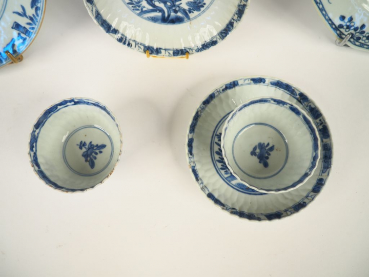 Paire de tasses et leurs coupelles et deux différentes assiettes en po