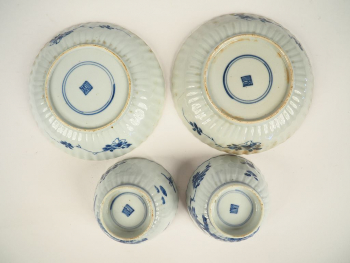 Paire de tasses et leurs coupelles et deux différentes assiettes en po