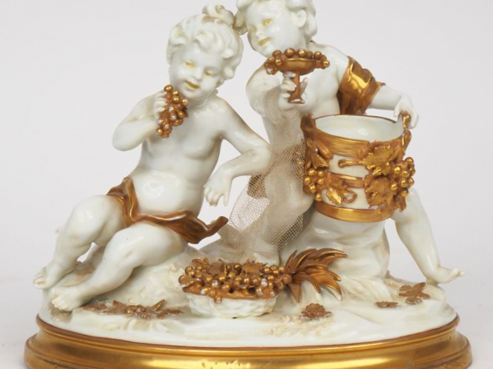 Groupe XIXème en porcelaine blanche et dorée à décor d'amours vendange