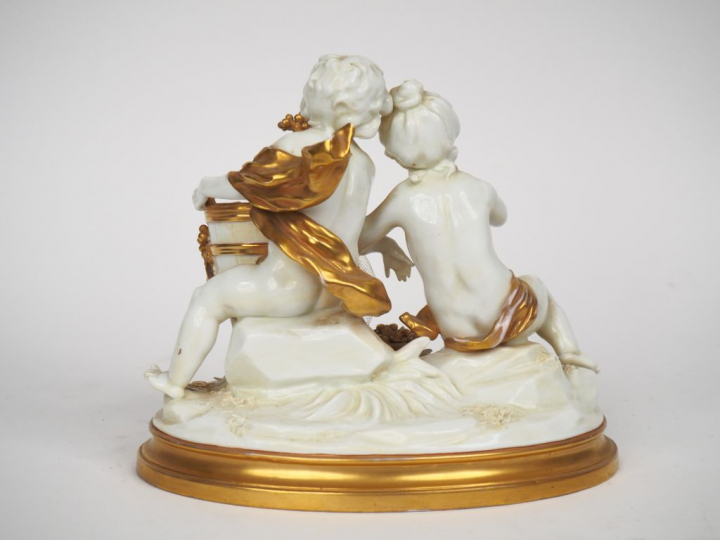 Groupe XIXème en porcelaine blanche et dorée à décor d'amours vendange