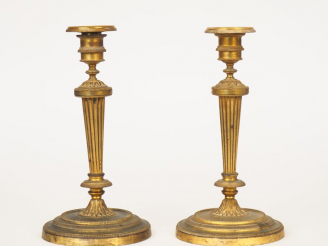 Vente aux enchères Paire de bougeoirs XIXème de style Louis XVI en bronze doré à décor de