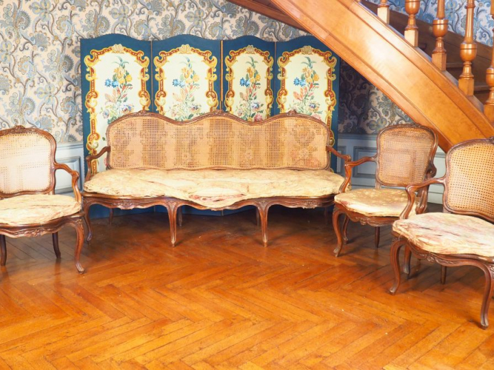 Trois fauteuils et un canapé Louis XV canné en noyer mouluré et sculpt