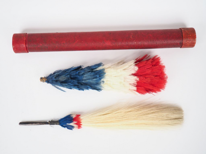 Tube en cartonnage rouge contenant deux attributs de coiffures françai