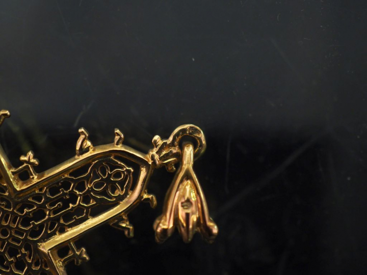 Pendentif en or jaune 750 en forme de croix, à décor ajouré.  5 x 3,5 