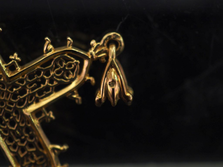 Pendentif en or jaune 750 en forme de croix, à décor ajouré.  5 x 3,5 