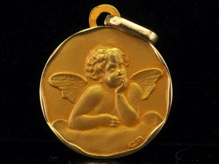 Médaille en or jaune 750, figurant un angelot.  Joli pourtour irréguli
