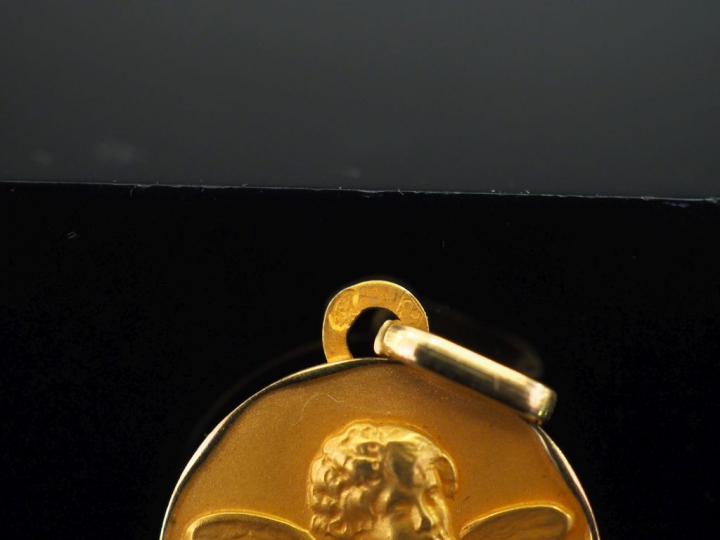 Médaille en or jaune 750, figurant un angelot.  Joli pourtour irréguli