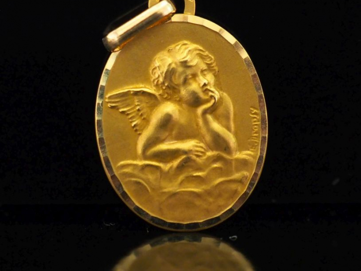 Médaille ovale en or jaune 750, figurant un angelot. 1,8 x 1,4 cm Poid