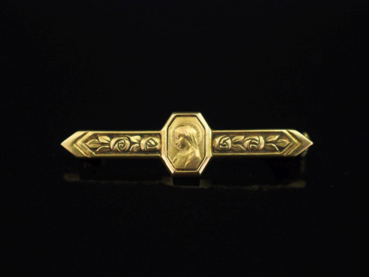 Petite broche barrette en or jaune 750, agrémentée en son centre d'un 