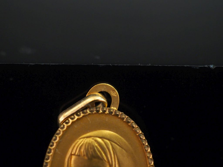 Médaille de forme ovale en or jaune 750, figurant une jeune femme au f