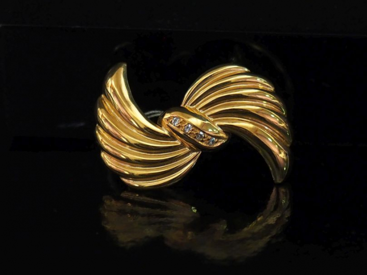 Broche en forme de nœud godronné en or jaune 750, sertie en son centre