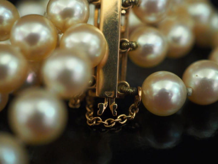 Bracelet manchette trois rangs de perles blanches.  Fermoir et chainet