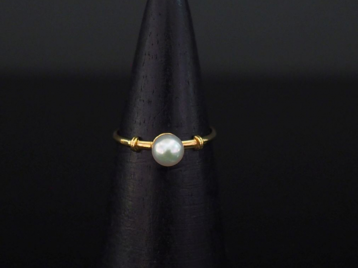 Petite bague en or jaune, sertie en son centre d'une perle blanche.  T