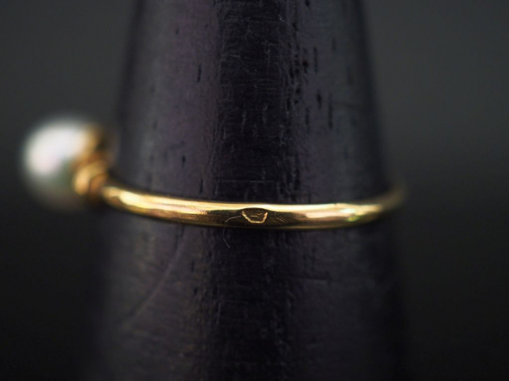 Petite bague en or jaune, sertie en son centre d'une perle blanche.  T