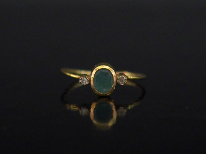 Bague en or jaune 750, sertie en son centre d'une émeraude épaulée de 