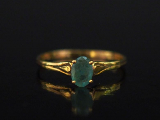 Vente aux enchères Petite bague en or jaune 750, sertie en son centre d'une émeraude.  Jo