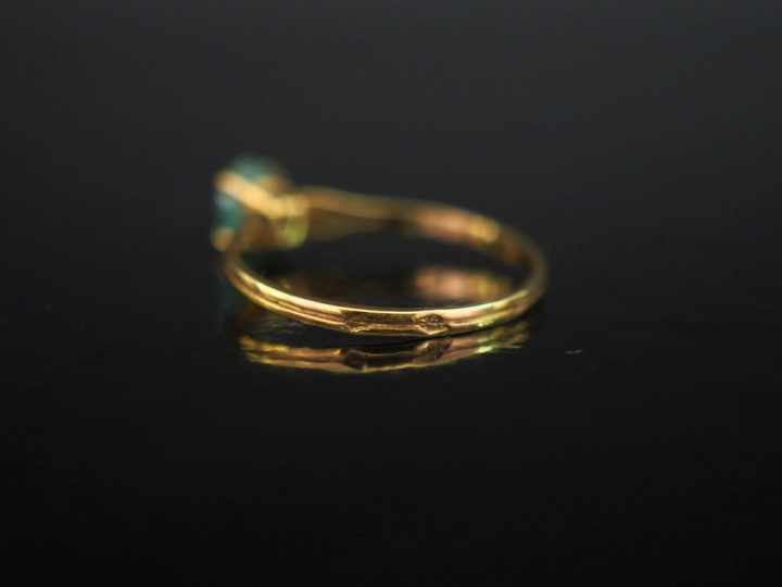 Petite bague en or jaune 750, sertie en son centre d'une émeraude.  Jo