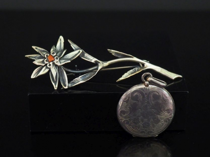 Broche en argent, en forme de fleur, le pistil à décor d'émail rouge. 