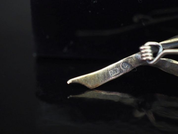 Broche en argent, en forme de fleur, le pistil à décor d'émail rouge. 