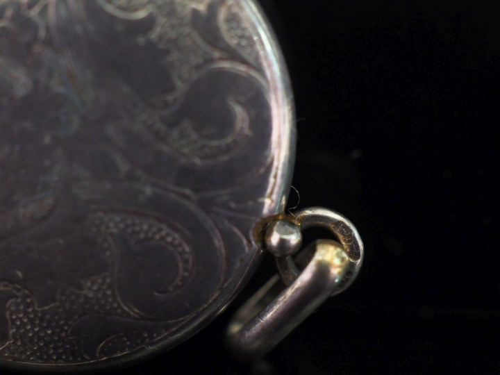 Broche en argent, en forme de fleur, le pistil à décor d'émail rouge. 