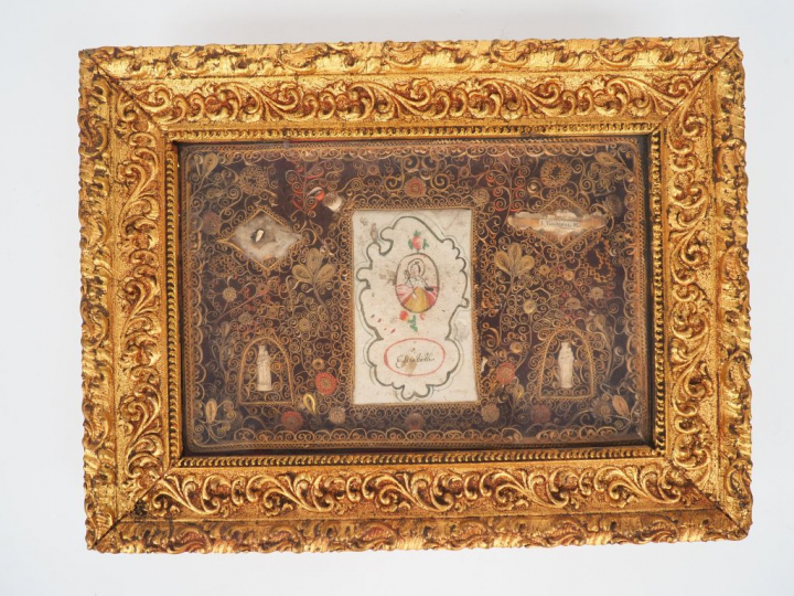 Reliquaire XIXème en paperolle, cadre en stuc doré.  Dim. 29 x 38,4 cm