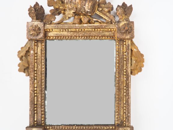 Miroir de style Louis XVI en bois sculpté et doré, fronton ajouré à dé