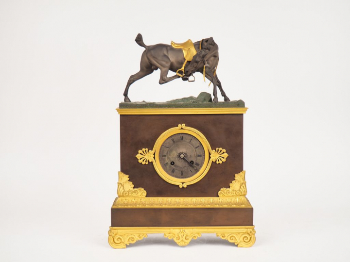 Pendule Restauration en bronze polychrome vert brun et doré, à décor d