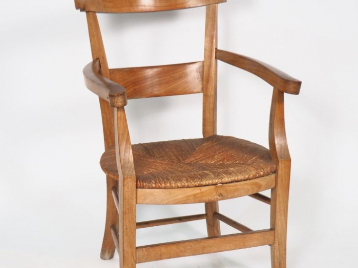 Fauteuil paillé de style Directoire en merisier.