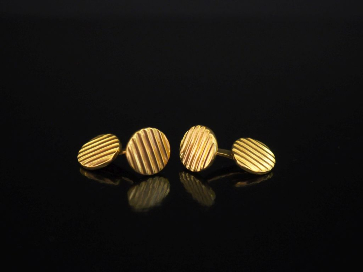 Paire de boutons de manchettes en or jaune 750, à décor de cannelures.