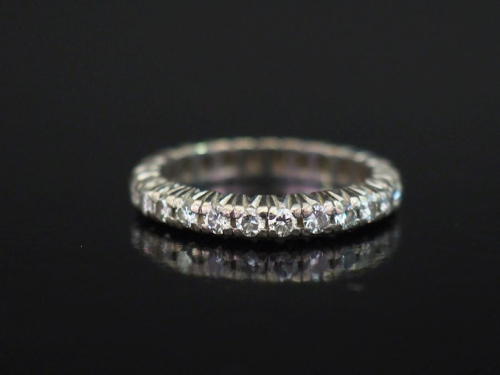 Alliance américaine en or blanc 750, sertie de petits diamants.  TDD. 