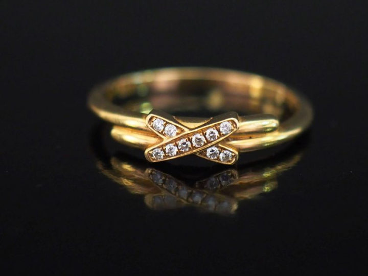 CHAUMET,  Bague "Jeux de liens" en or june 750, sertie en son centre d