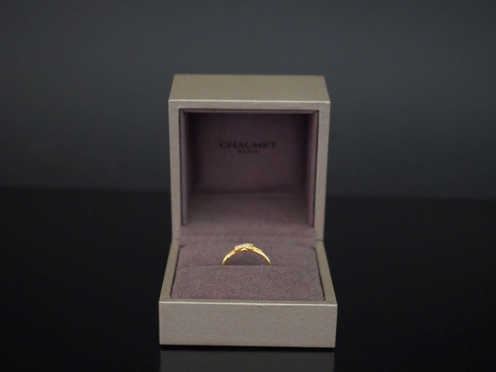 CHAUMET,  Bague "Jeux de liens" en or june 750, sertie en son centre d