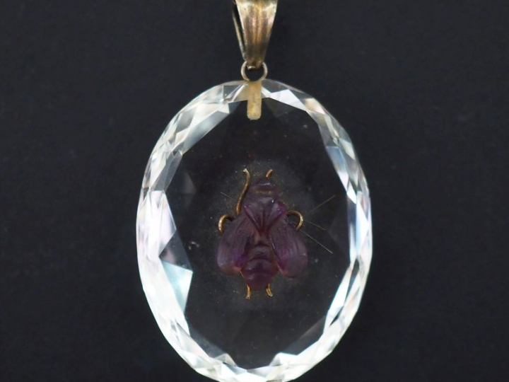 Pendentif de forme ovale orné d'une pierre facettée et agrémentée en s