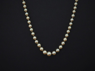 Vente aux enchères Collier de perles blanches disposées en chute.  Fermoir en argent 925,