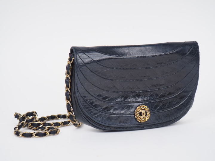 Sac bandoulière de forme besace en cuir bleu marine.  Fermeture à raba