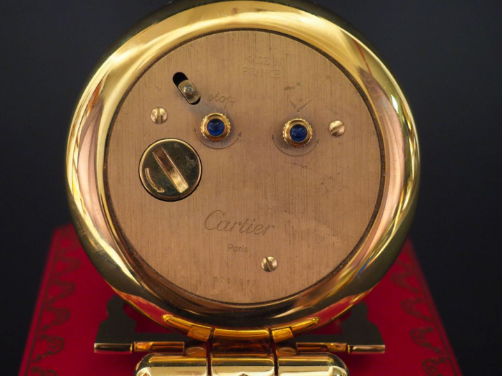 CARTIER, Must Pendulette de table réveil en métal doré, modèle "Colisé