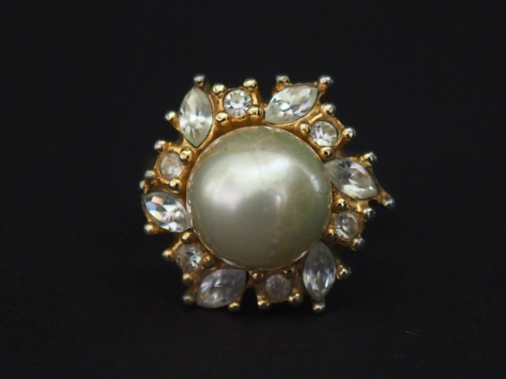 Christian DIOR,  Bague en métal doré, sertie en son centre d'une perle