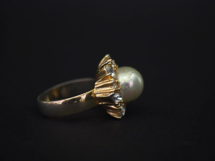 Christian DIOR,  Bague en métal doré, sertie en son centre d'une perle