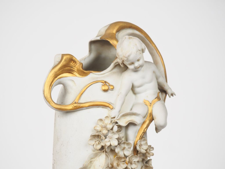 Vase Art Nouveau en biscuit blanc et doré, à décor en relief d'amours 