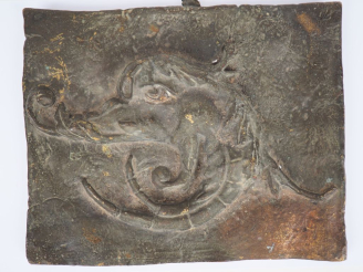 Vente aux enchères Plaque décorative en fonte à patine verte à décor de tête de chimère. 