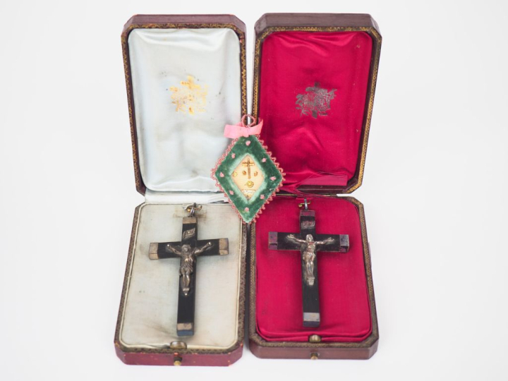 Deux crucifix en bois noirci et métal argenté dans leurs écrins gainés